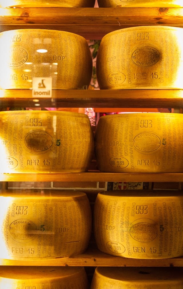 Cheese wheels stacked somewhere in Bologna, Italy. (Photo: Max Nayman via Unsplash)