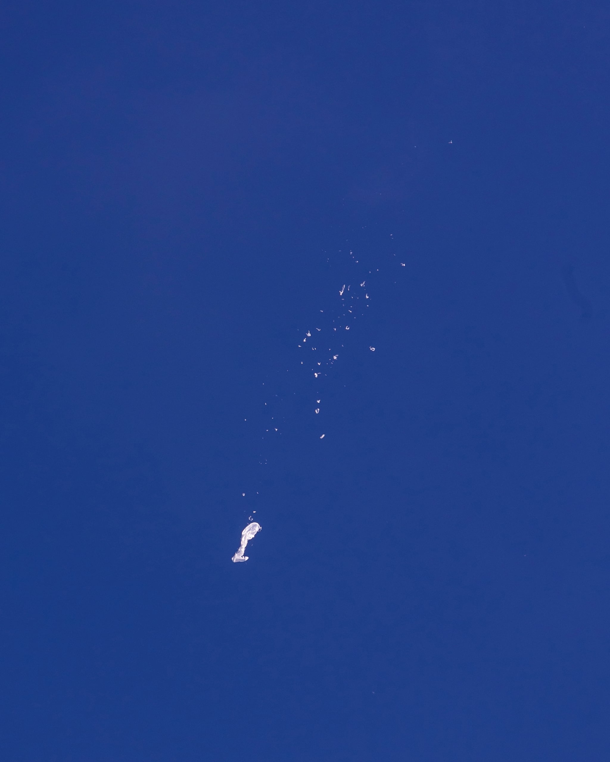 In this photo provided by Chad Fish, the remnants of a large balloon drift above the Atlantic Ocean, just off the coast of South Carolina, Saturday, Feb. 4, 2023. The downing of the suspected Chinese spy balloon by a missile from an F-22 fighter jet created a spectacle over one of the state’s tourism hubs and drew crowds reacting with a mixture of bewildered gazing, distress and cheering. (Chad Fish via AP) In this photo provided by Chad Fish, the remnants of a large balloon drift above the Atlantic Ocean, just off the coast of South Carolina, Saturday, Feb. 4, 2023. The downing of the suspected Chinese spy balloon by a missile from an F-22 fighter jet created a spectacle over one of the state’s tourism hubs and drew crowds reacting with a mixture of bewildered gazing, distress and cheering. (Chad Fish via AP)