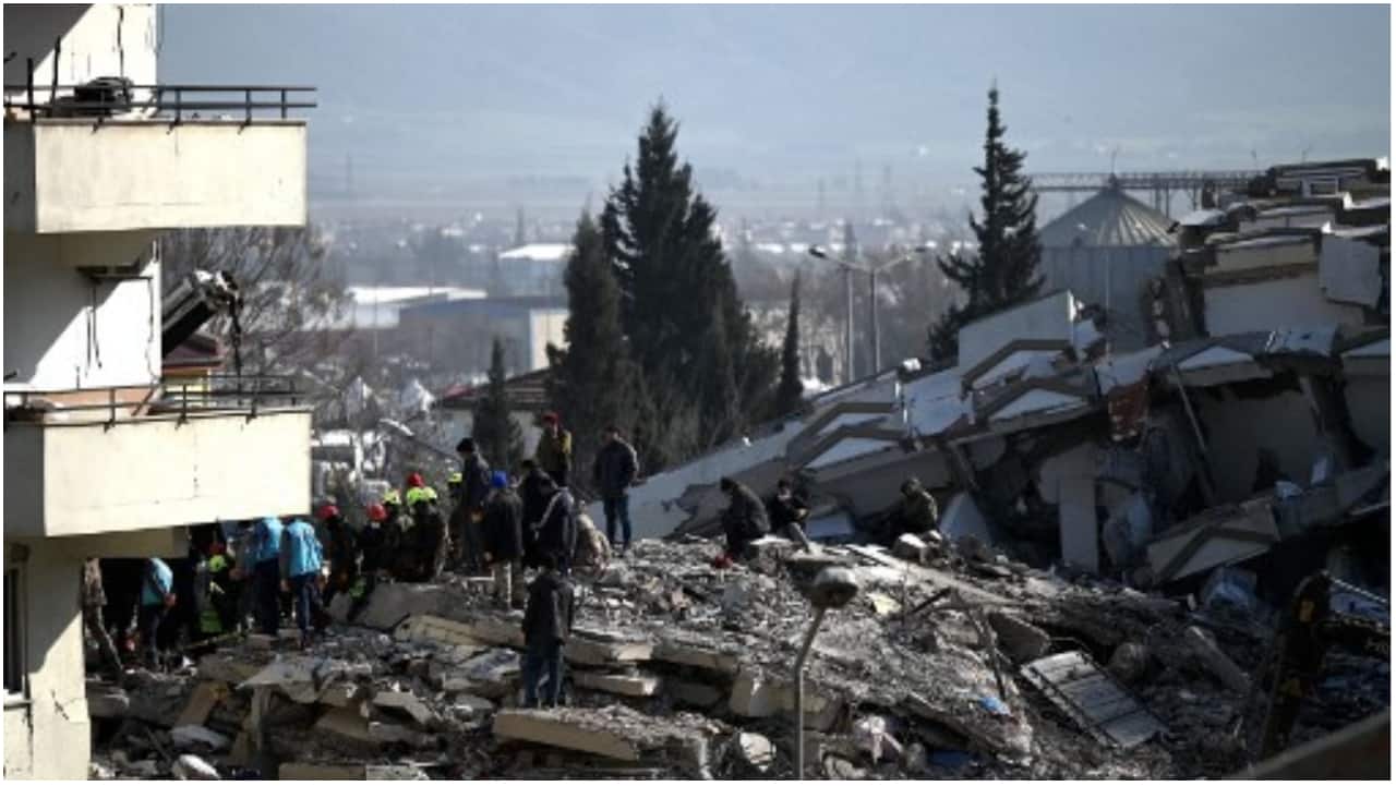 People wait as rescuers carry out search operations among the rubble of collapsed buildings in Kahramanmaras, on February 9, 2023, three days after a 7,8-magnitude earthquake struck southeast Turkey. 