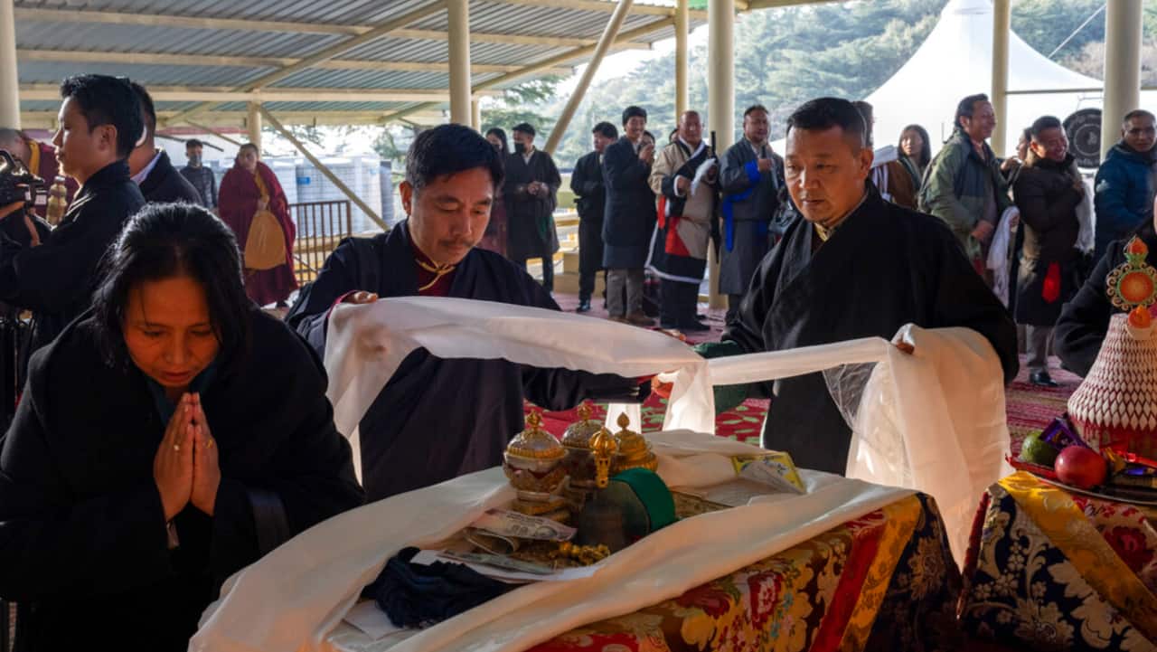 Exile Tibetans offer ceremonial scarves in front of an altar during an early morning prayer session to usher in the Year of the Water Hare in Dharamshala.