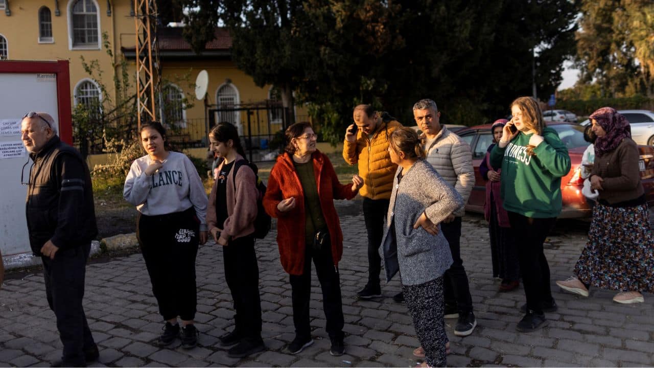 Sabriye Karan (4th-L) talks to a woman while queueing for a free meal from an aid organisation, with her daughter Nehir Karan (3rd-L) outside Iskenderun train station, where train carriages have been turned into temporary shelters for victims of the recent deadly earthquake, in Iskenderun, Turkey, February 22. (Source: Reuters)