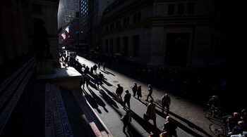Pedestrians walk along Wall Street near the New York Stock Exchange (NYSE) in New York, U.S., on Monday, Oct. 31, 2016. U.S. stocks rose from a six-week low amid an increase in deal activity as traders assessed the outlook for the presidential election and interest rates in the world's largest economy. Photographer: Michael Nagle/Bloomberg