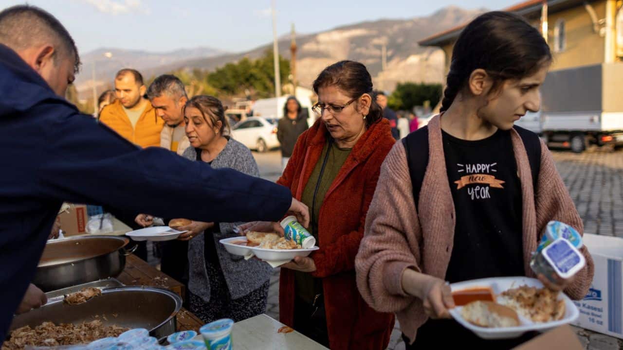 Sabriye Karan and her daughter Nehir Karan receive free meals from an aid organisation outside Iskenderun train station, where train carriages have been turned into temporary shelters for victims of the recent deadly earthquake, in Iskenderun, Turkey, February 22. (Source: Reuters)