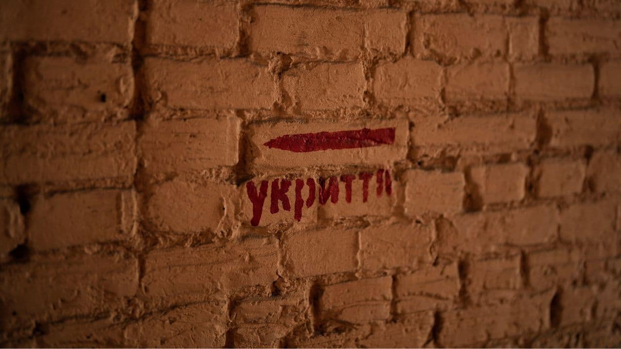 Signs painted on walls point to the nearest shelter, while air raid sirens occasionally wail across the city, which still sometimes comes under missile attack. (Source: AP) Signs painted on walls point to the nearest shelter, while air raid sirens occasionally wail across the city, which still sometimes comes under missile attack. (Source: AP)