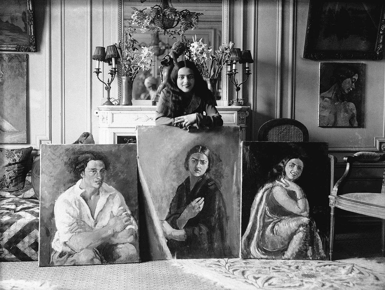 Amrita Sher-Gil with 3 paintings Photo by Umrao Singh Sher-Gil via Wikimedia Commons