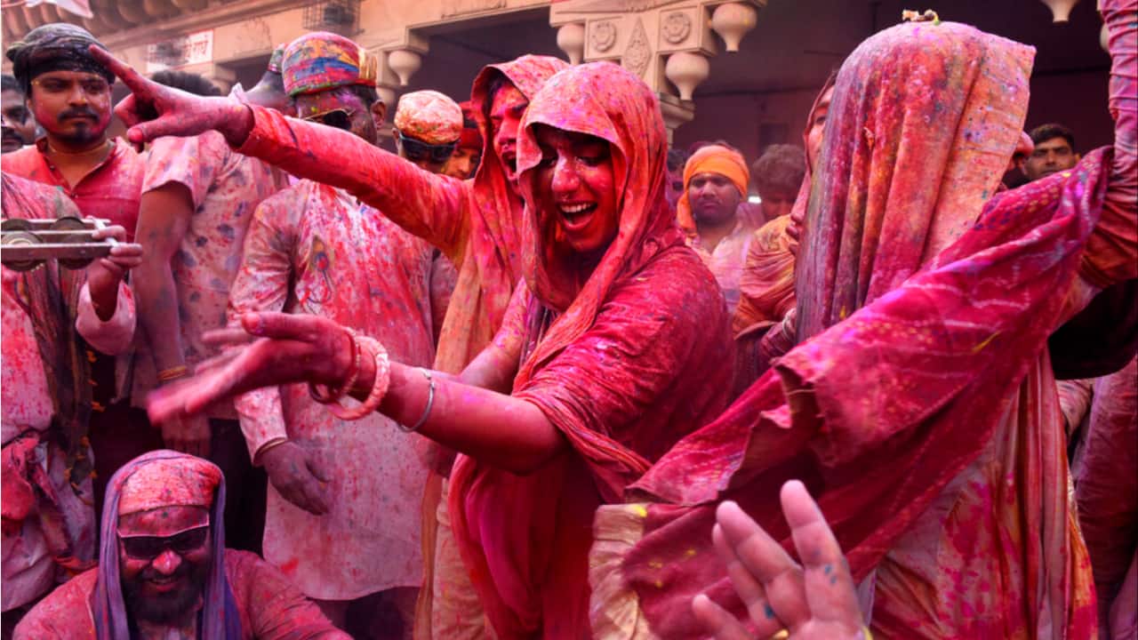 People smeared with colors play Holi at Nandagram temple in Nandgoan village, 115 kilometers south of New Delhi.