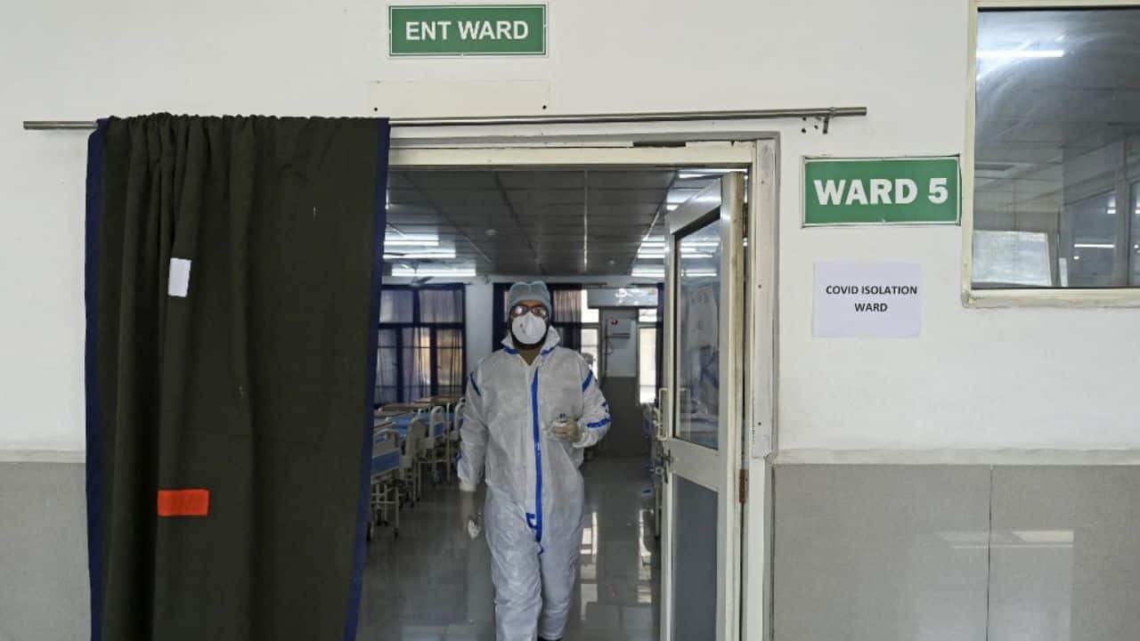 A health worker wearing personal protective equipment (PPE) walks out from a Covid isolation ward during a mock drill to check preparations of Covid-19 facilities at JLNM hospital in downtown Srinagar. (Image: AFP)