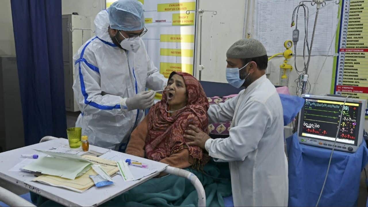 A patient reacts as a health worker wearing personal protective equipment (PPE) takes nasal swab samples to test for the Covid-19 coronavirus at JLNM hospital in downtown Srinagar. (Image: AFP)