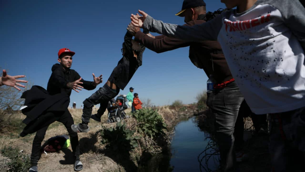 Migrants cross the Rio Grande river into the United States from Ciudad Juarez, Mexico, Wednesday, March 29, 2023, a day after dozens of migrants died in a fire at a migrant detention center in Ciudad Juarez.