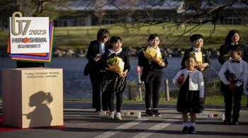 Children wait with flowers and violins for a welcome ceremony for a G7 Foreign Ministers' Meeting in Karuizawa on April 16, 2023. (AFP)