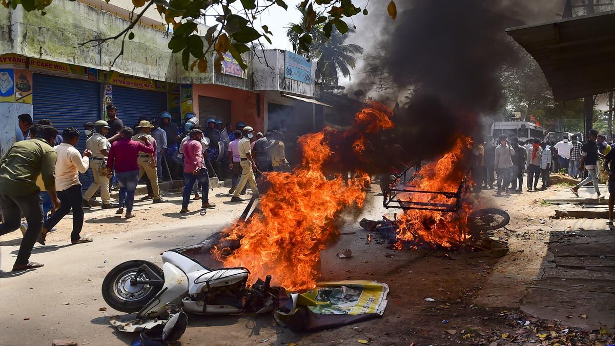 Vehicles set on fire by rioters during a procession, as tension spreads in Shivamogga town over the murder of a member of right-wing outfit Bajrang Dal in Shivamogga. | Photo Credit: PTI