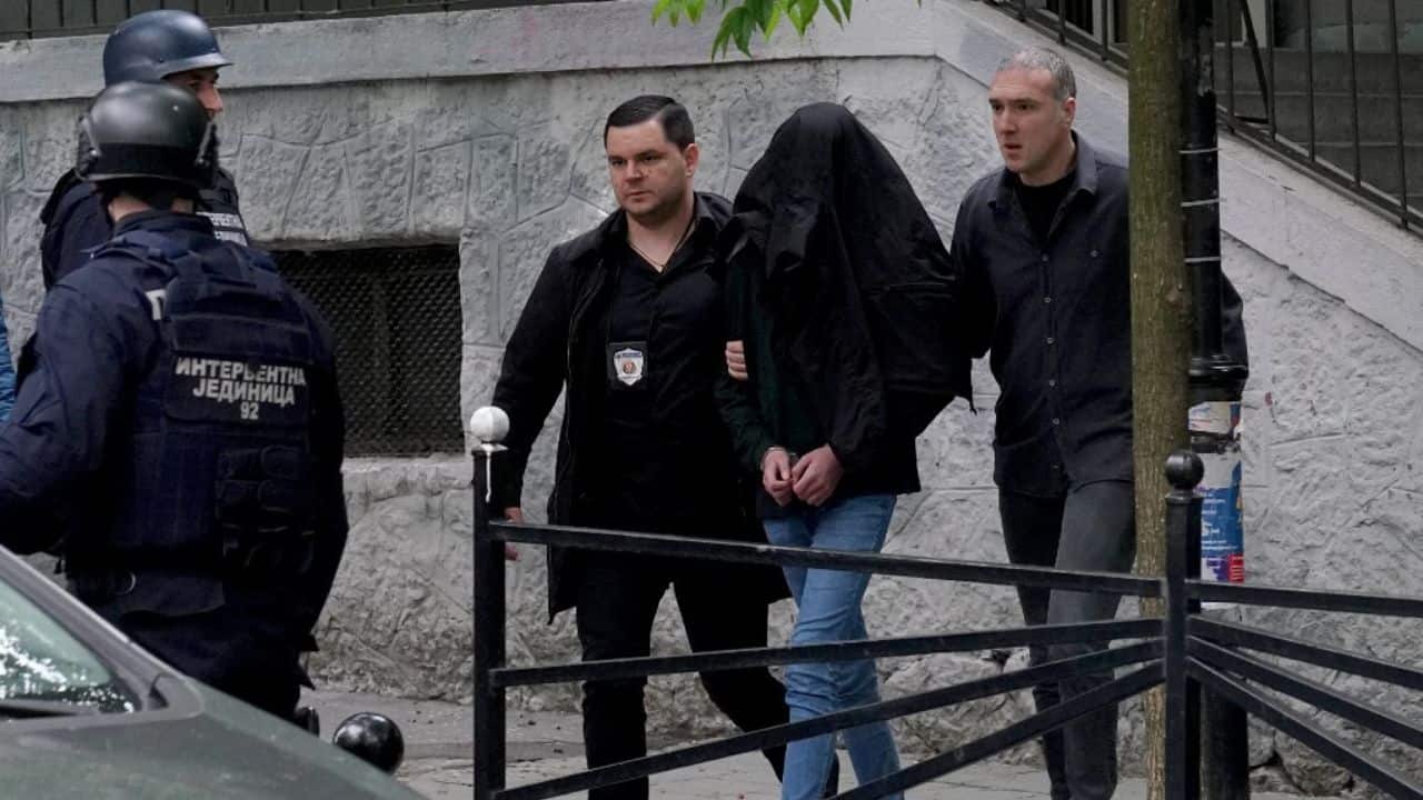 Local media footage from the scene showed commotion outside the school as police removed the suspect, whose head was covered as officers led him to a car parked in the street. (Image: AFP)