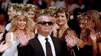 German fashion designer Karl Lagerfeld acknowledges the applause of his models at the end of the show he designed for the French fashion house Chanel, for the 1993-94 Fall-Winter haute couture collection in Paris, July 20, 1993.