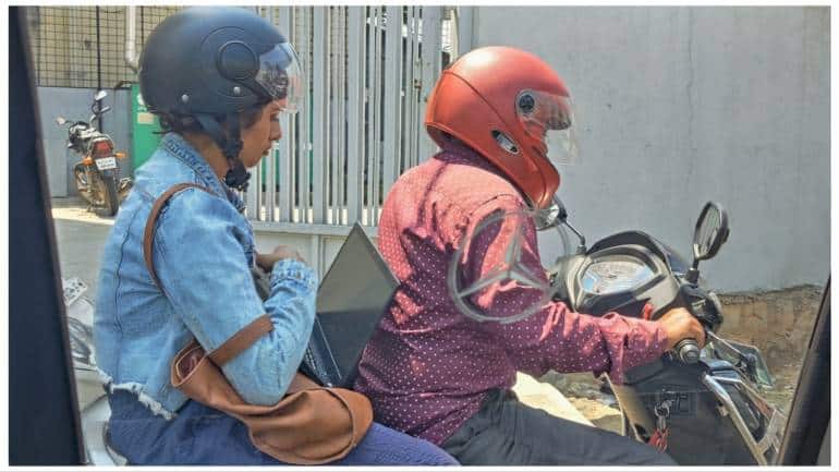 Stuck in Bengaluru traffic, woman works on laptop on Rapido bike - Vimarsana News