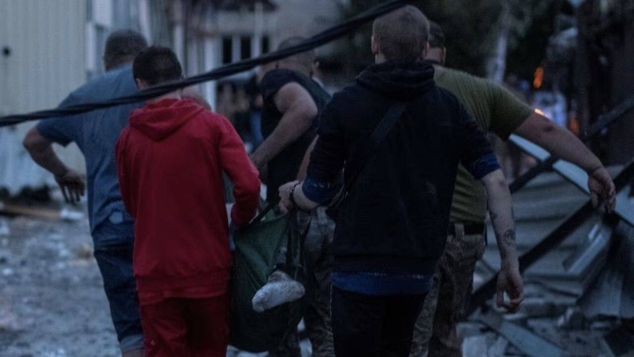 Despite Russia's denial of targeting civilian sites, volunteers were seen assisting an injured individual at the location of severely damaged hotel and restaurant buildings, resulting from the recent attack. (Image: Reuters)