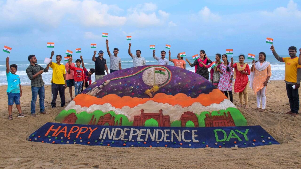 Students of Sudarsan Sand Art School creates a sand sculpture showing Chandrayaan 3 and wishing the 77the Independence Day on its eve, at Puri beach. (Image: PTI)