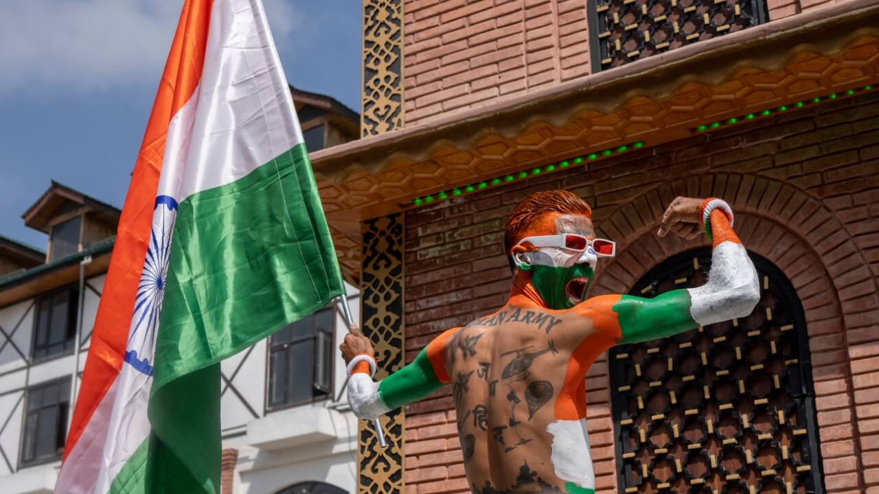 A man painted in three colours of the Indian national flag poses for photographs while celebrating Independence Day in Srinagar. (Image: AP)
