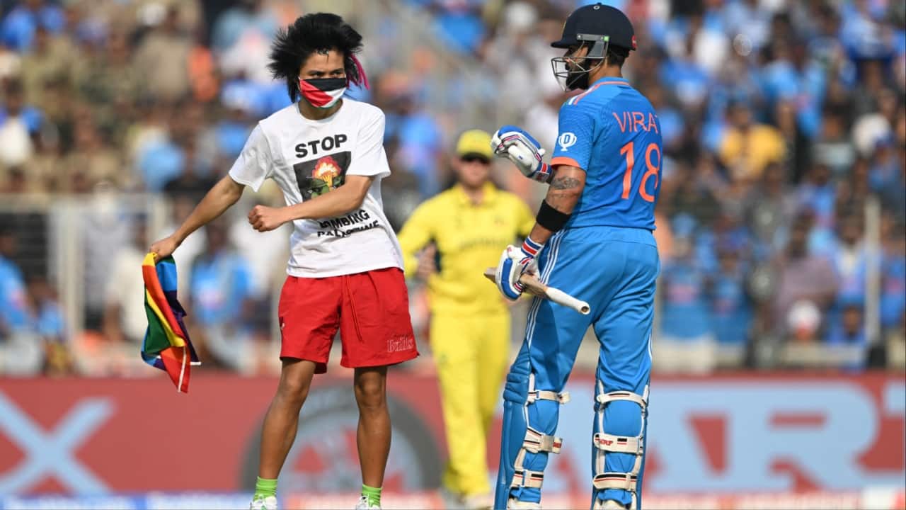 The pitch invader carries a flag of Palestine. (Image credit: AFP)