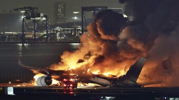 The Japan Airlines plane on fire on the runway of Haneda airport on Tuesday. (Image credit: AP)