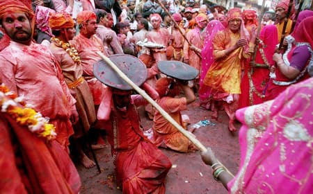 Indian women beat men with wooden sticks during the Lathmar Holi festival in Barsana, some 100 km from New Delhi, 25 February 2007. During the Lathmar Holi festival, the women of Barsana, the legendary hometown of Radha, consort of Hindu God Krishna, attack the men from Nandgaon, the hometown of Hindu God Krishna, with wooden sticks in response to their efforts to put color on them. AFP PHOTO/ MANAN VATSYAYANA