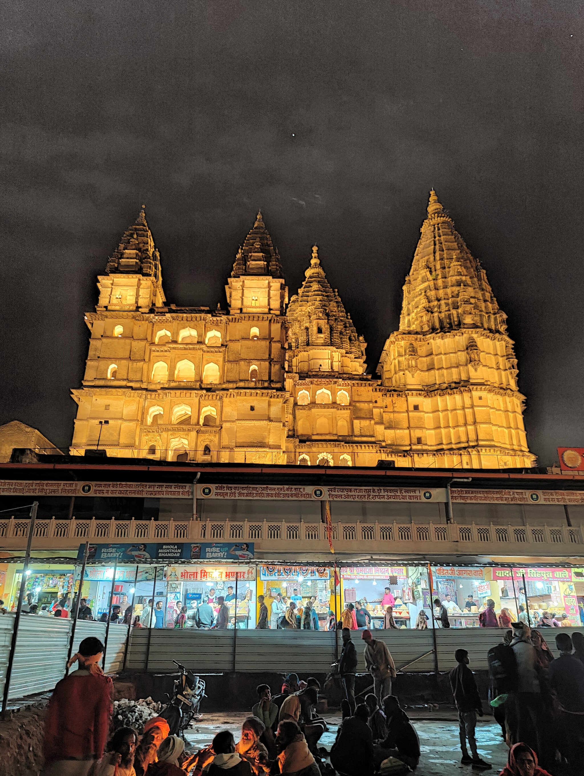 Evening at the Ram temple: Stalls selling mounds of kalakand, flowers, and religious paraphernalia and devotees dressed in finery, lead to the Ram temple complex which includes both the in-worship Ram Raja Temple where Lord Rama is worshipped as a king, holding a sword and shield and the old Chaturbhuj Temple (above). The Chaturbhuj temple was constructed by King Madhukar Shah in 1600, with rising towers and stark interiors, as Lord Ram for whom it was built chose to reside in the queen’s palace. Listen to the story behind the Ram Raja Temple, where the queen was a worshipper of Lord Ram and he manifested as a child in her lap. (Photo credit: Kalpana Sunder)