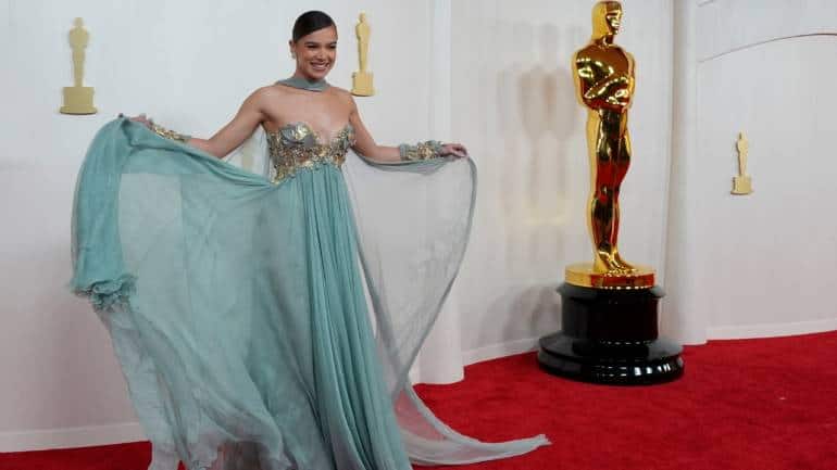 Hailee Steinfeld, often a style icon, failed to wow in an Elie Saab creation. The billowy chiffon gown seemed outdated, lacking the modern elegance expected at the Oscars. Despite impeccable hair and makeup, the dress fell short of expectations (Image: Canva)