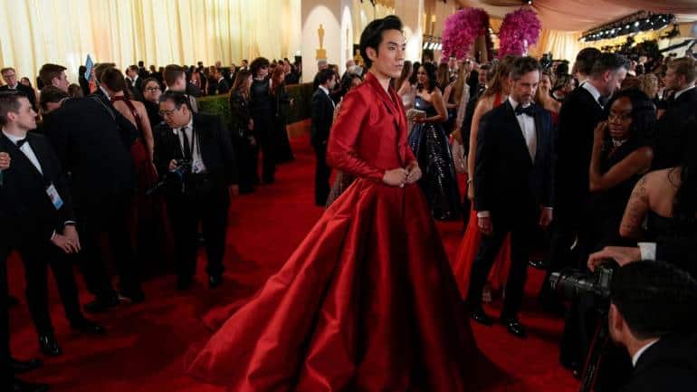 Eugene Lee Yang made a dramatic entrance in a voluminous burgundy statement skirt and matching jacket, reflecting his role in Netflix's animated sci-fi comedy &quot;Nimona&quot; (Image: AP)