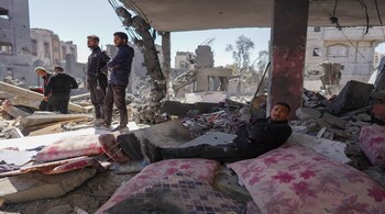 Palestinians sit on the rubble of a destroyed house following overnight Israeli bombardment which hit the al-Habash family home at the Nuseirat refugee camp in the central Gaza Strip on March 20, 2024, amid ongoing battles between Israel and the militant group Hamas. (Photo by AFP)