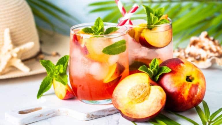 Peaches and mint iced tea: Brew black tea with slices of juicy peaches and fragrant mint leaves, then let it chill in the refrigerator until cold. Serve the iced tea over ice with a garnish of fresh mint (Image: Canva)