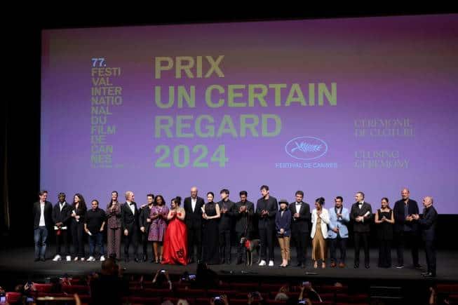 CANNES, FRANCE - MAY 24: Boris Lojkine, Abou Sangare, Louise Courvoisier, Tawfik Alzaidi, Vicky Krieps, Todd McCarthy, Xavier Dolan, Maïmouna Doucouré, Asmae El Moudir, Guan Hu, Liang Jing, Eddie Li, Anasuya Sengupta, Abdullah Al-Sadhan, Roberto Minervini, Maria Bahrawi and Bandar Alabdulsalam pose onstage during the Un Certain Regard closing ceremony at the 77th annual Cannes Film Festival at Palais des Festivals on May 24, 2024 in Cannes, France. (Photo by Cindy Ord/Getty Images) | Photo Credit: CINDY ORD