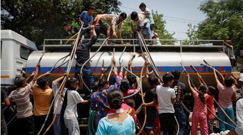 Residents fill their containers with drinking water from a municipal tanker on a hot summer day in New Delhi. (Image credit: Reuters)