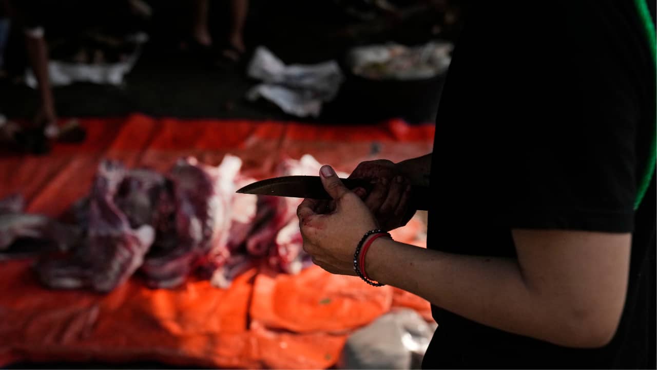  A man holds a knife as he cut up carcasses of goats whose meat would later be distributed to the needy during the celebration of Eid al-Adha in Jakarta, Indonesia, Monday, June 17, 2024. Muslims around the world are celebrating Eid al-Adha, or the Feast of the Sacrifice by slaughtering livestock to commemorate Prophet Abraham's (Abraham to Christians and jews) readiness to sacrifice his son Ismail on God's command. (AP Photo