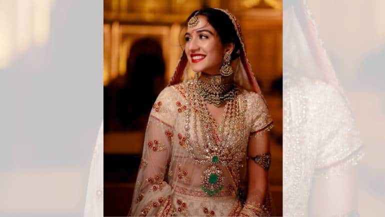  The custom bridal outfit was a breathtaking ivory Zardozi cut-work creation, consisting of multiple layers and elements that showcased her love for heritage. The ensemble featured a layered ghagra with a second detachable trail, creating an ethereal, flowing silhouette. The ghagra was adorned with three borders of red, adding a vibrant contrast to the ivory base (Image: @rheakapoor, @abujanisandeepkhosla/Instagram)