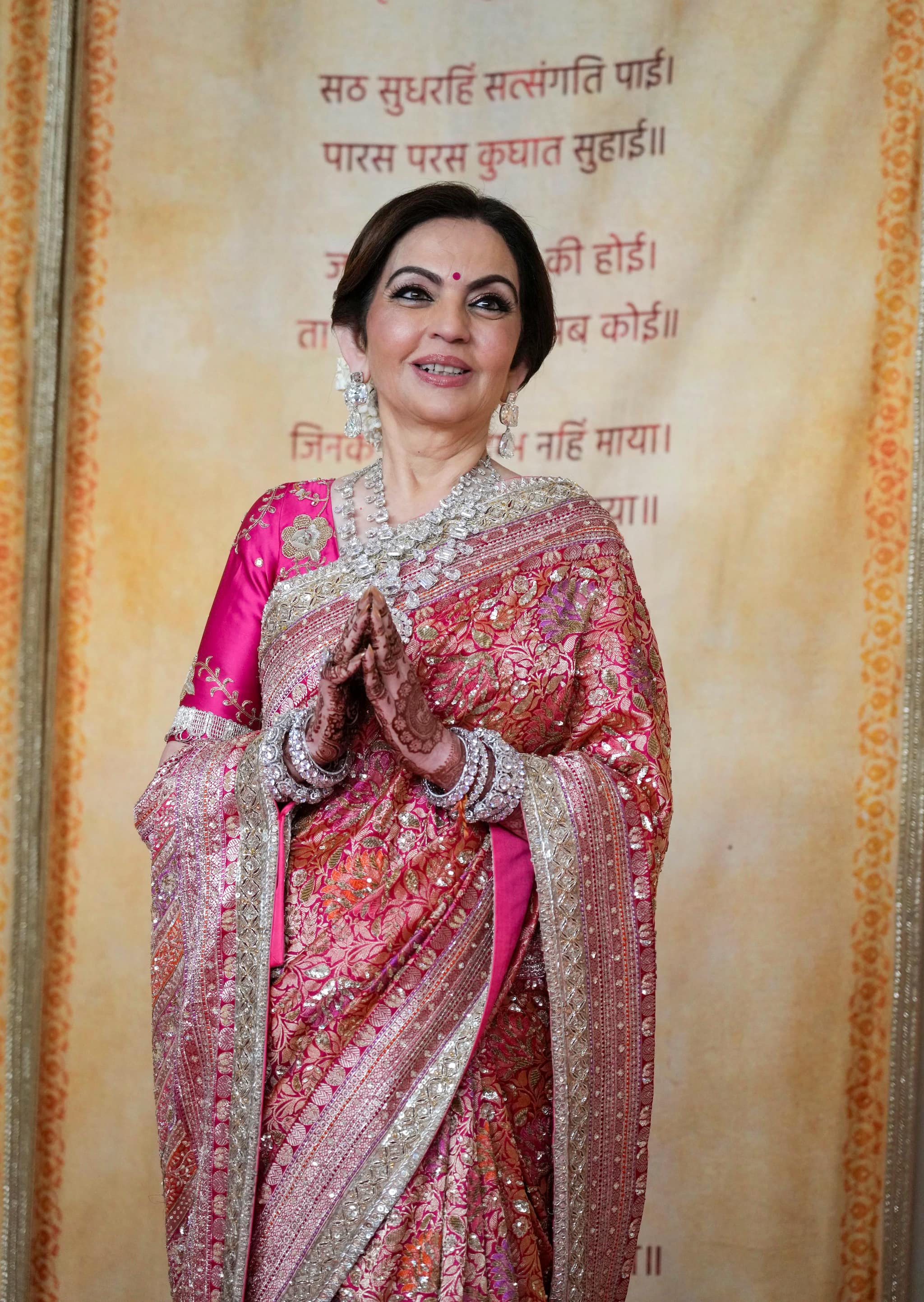 Nita Ambani greets media personnel at the wedding reception of her son Anant Ambani and Radhika Merchant in Mumbai, India, Sunday, July 14, 2024. (AP Photo/Rafiq Maqbool)