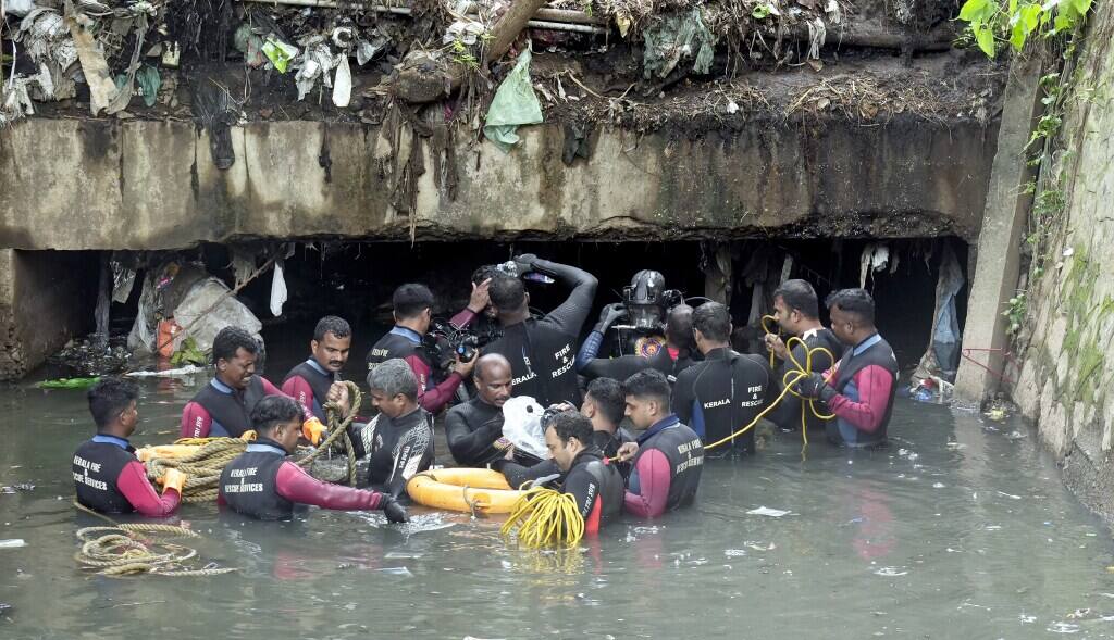 Kerala Fire and Rescue Services personnel during a search operation after a sanitation worker was swept away in rainwater while cleaning the Amayizhanchan canal on Saturday, in Thiruvananthapuram, Sunday, July 14, 2024. Joy (47), a temporary cleaning worker, went missing while cleaning the waste-filled canal criss-crossing through the heart of the capital city on Saturday. (PTI Photo) 