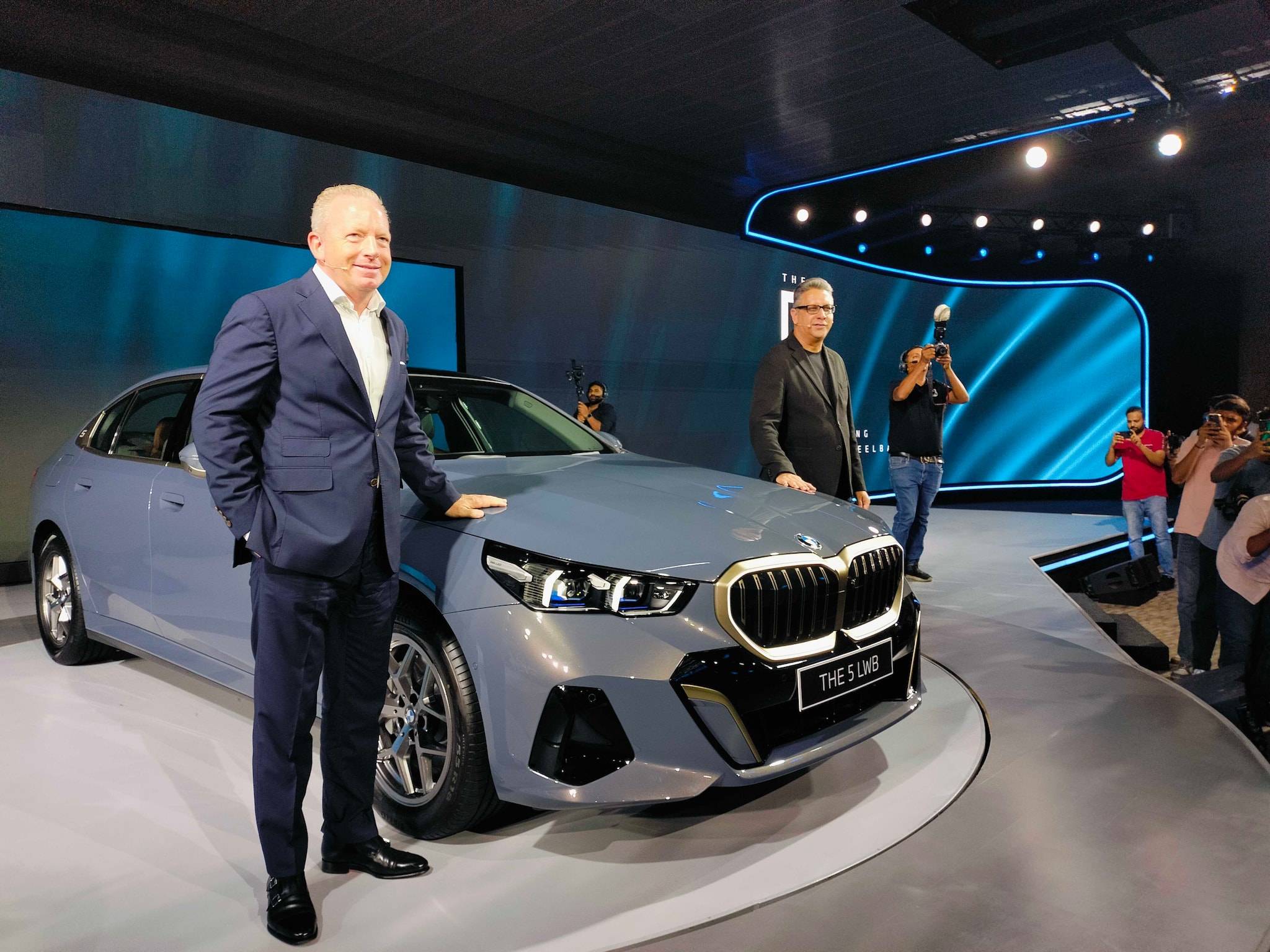 Inside, the 5 Series offers unparalleled luxury with vegan leather upholstery, advanced comfort features, and a spacious cabin. The interior includes a fully digital BMW Curved Display, BMW Interaction Bar, and a premium Bowers &amp; Wilkins Surround Sound System. For the first 500 customers, individually customized rear headrest cushions will be provided.