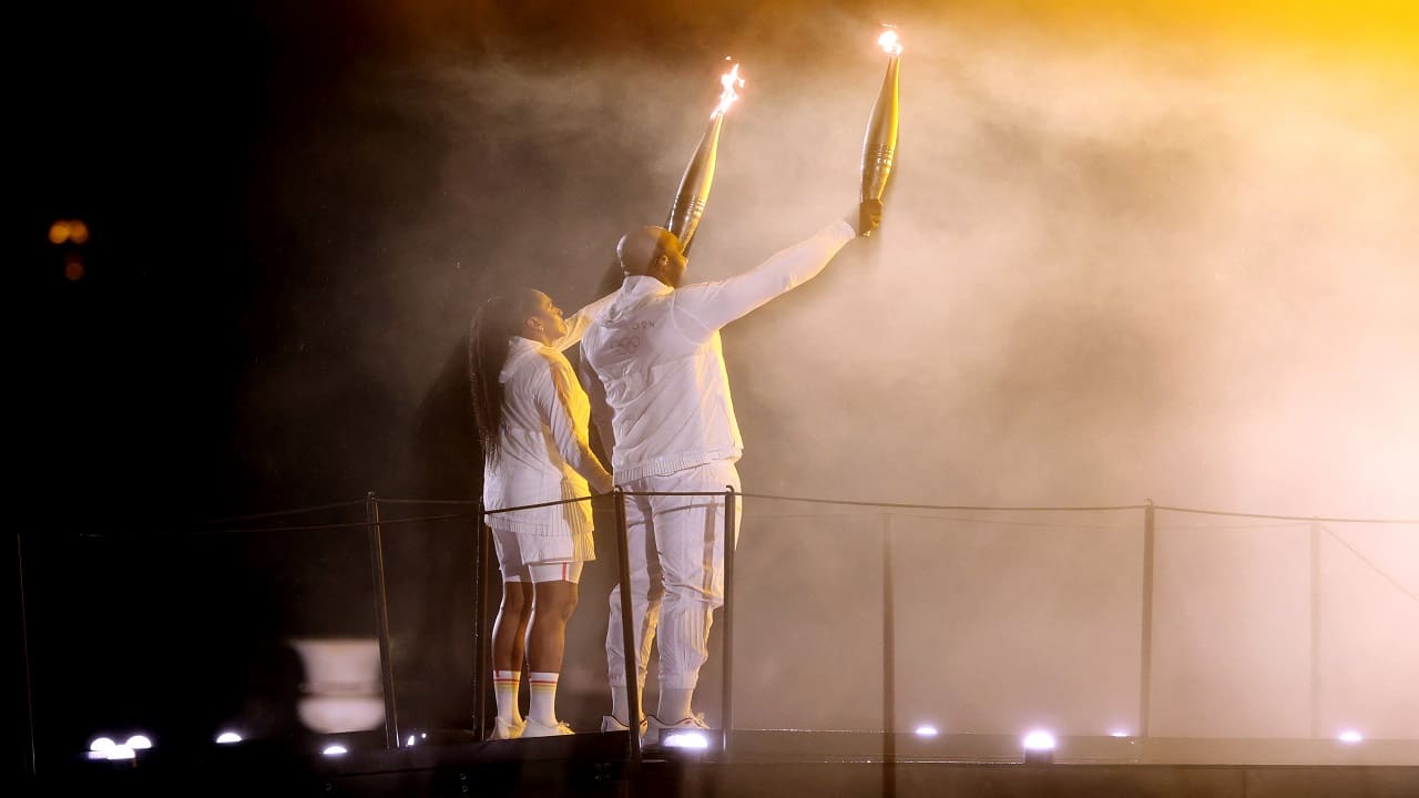 Torchbearers Teddy Riner and Marie-Jose Perec light the Olympic cauldron 