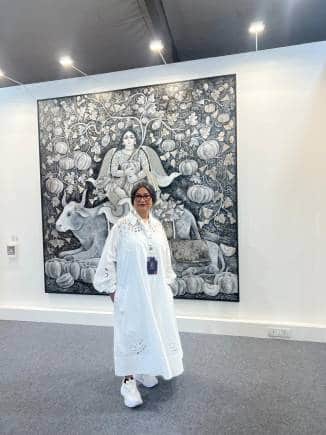 Jayasri Burman with an artwork from her series Dhārā (2023), which explores the connection between motherhood and nature, from an exhibition in Mumbai last year. (Photo courtesy the artist)