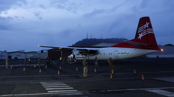 Members of the National Border Service (SENAFRONT) keep watch as Colombian migrants, who were detained after crossing into Panama irregularly through the dangerous Darien Gap