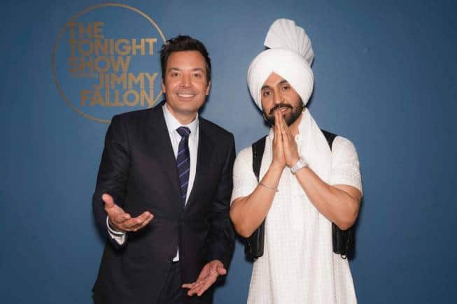 Diljit Dosanjh wearing a Raghavendra Rathore bespoke outfit alongside Jimmy Fallon. 