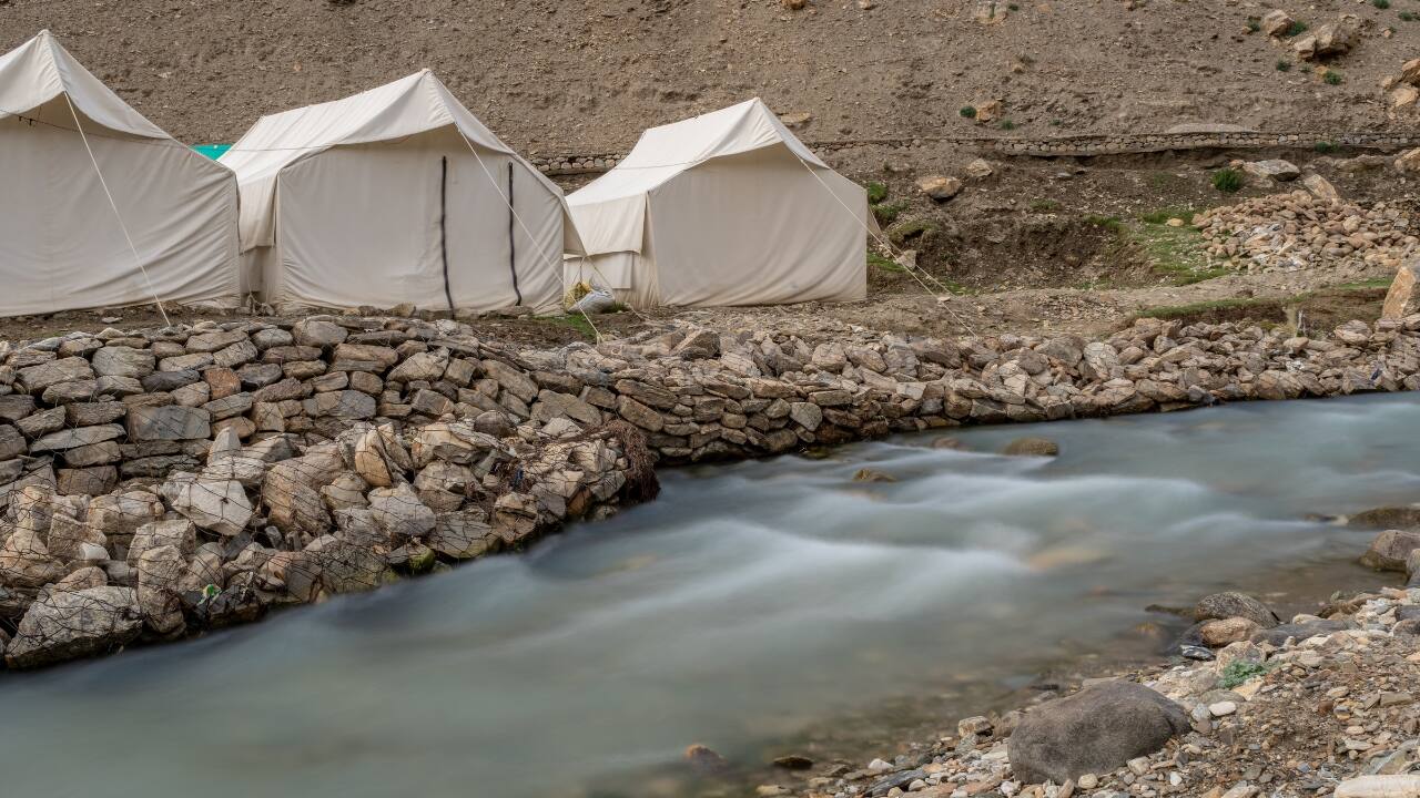 4. Tso Moriri, Ladakh: A High-Altitude Hidden Gem Imagine camping beside a pristine, high-altitude lake at 15,000 feet—Tso Moriri in Ladakh offers just that! Surrounded by towering mountains, the serene blue waters of Tso Moriri make for one of the most spectacular camping spots in India. The isolation, rugged terrain, and harsh yet beautiful landscape make it a once-in-a-lifetime adventure for nature enthusiasts craving an offbeat experience. (Image: Canva)