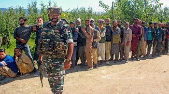 Voters wait in a queue at a polling station during the first phase of Assembly elections, in Shopian district of south Kashmir. (PTI Photo)