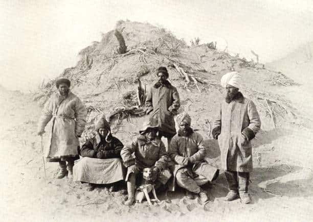 Photograph of Aurel Stein with his dog "Dash" and expedition team including R.B Lal Singh Mehta in the Tarim Basin, Northwest China, c. 1910
