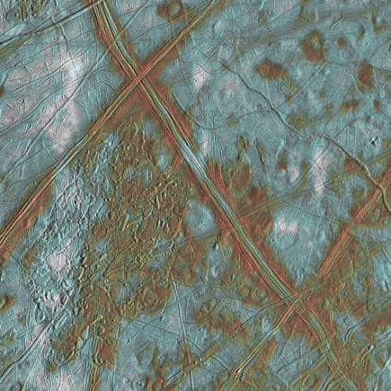 The Galileo probe revealed a captivating view of Europa’s surface, featuring domes, ridges, and red patches containing organic or carbon-based molecules. (Image: NASA)