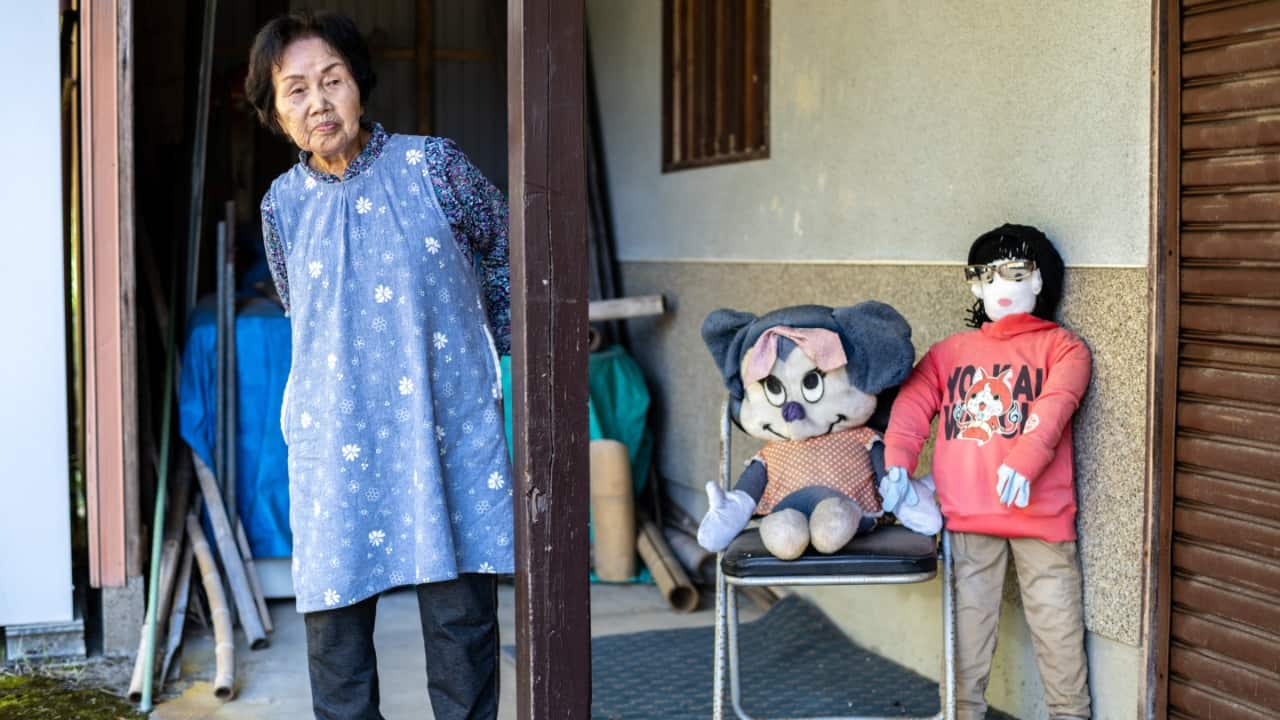 Hisayo Yamazaki stands next to the puppets outside her house in the village of Ichinono in the city of Tamba-Sasayama, Hyogo Prefecture. (Image credit: AFP)