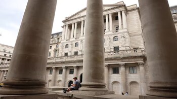 A man sits by the Bank of England in the financial district of London, Britain