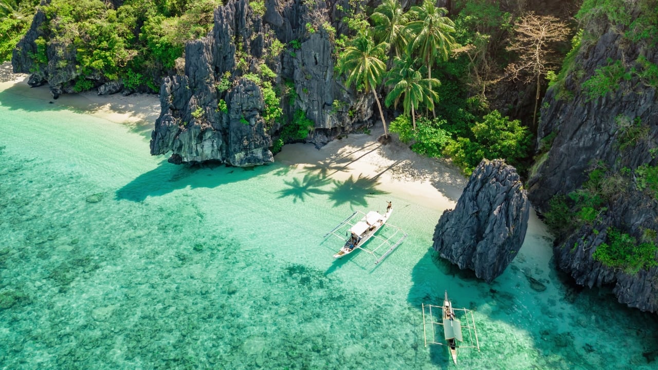 Discover El Nido’s stunning beaches and crystal-clear waters for the ultimate tropical getaway. (Image: Canva)