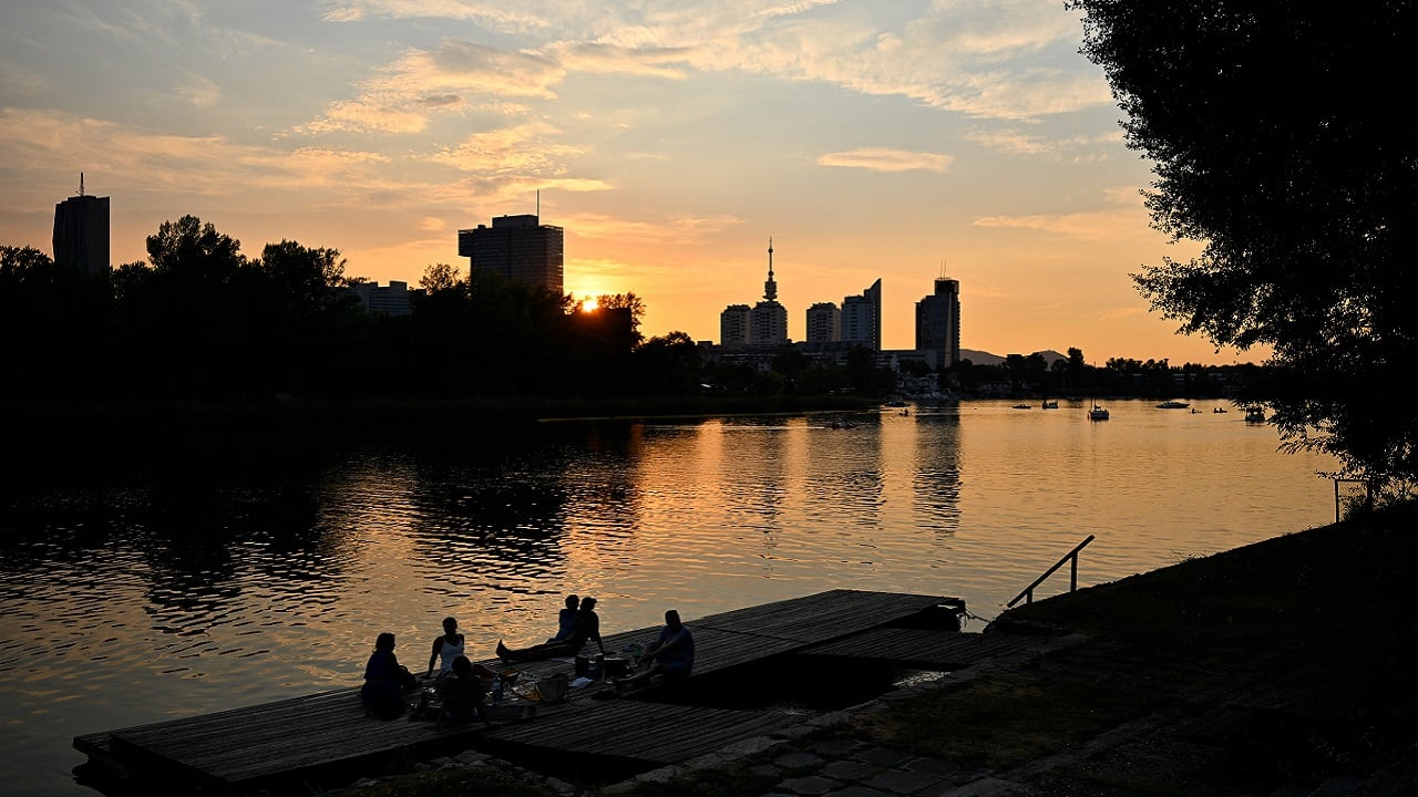 FILE PHOTO: People enjoy the sunset at Alte Donau, an abandoned meander of the river Danube during a heat wave in Vienna, Austria, August 14, 2024. REUTERS/Elisabeth Mandl/File Photo
