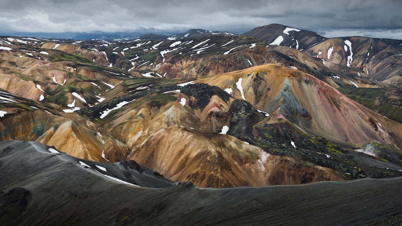Explore colorful mountains and geothermal hot springs in Landmannalaugar, an eco-adventure paradise. (Image: Canva)