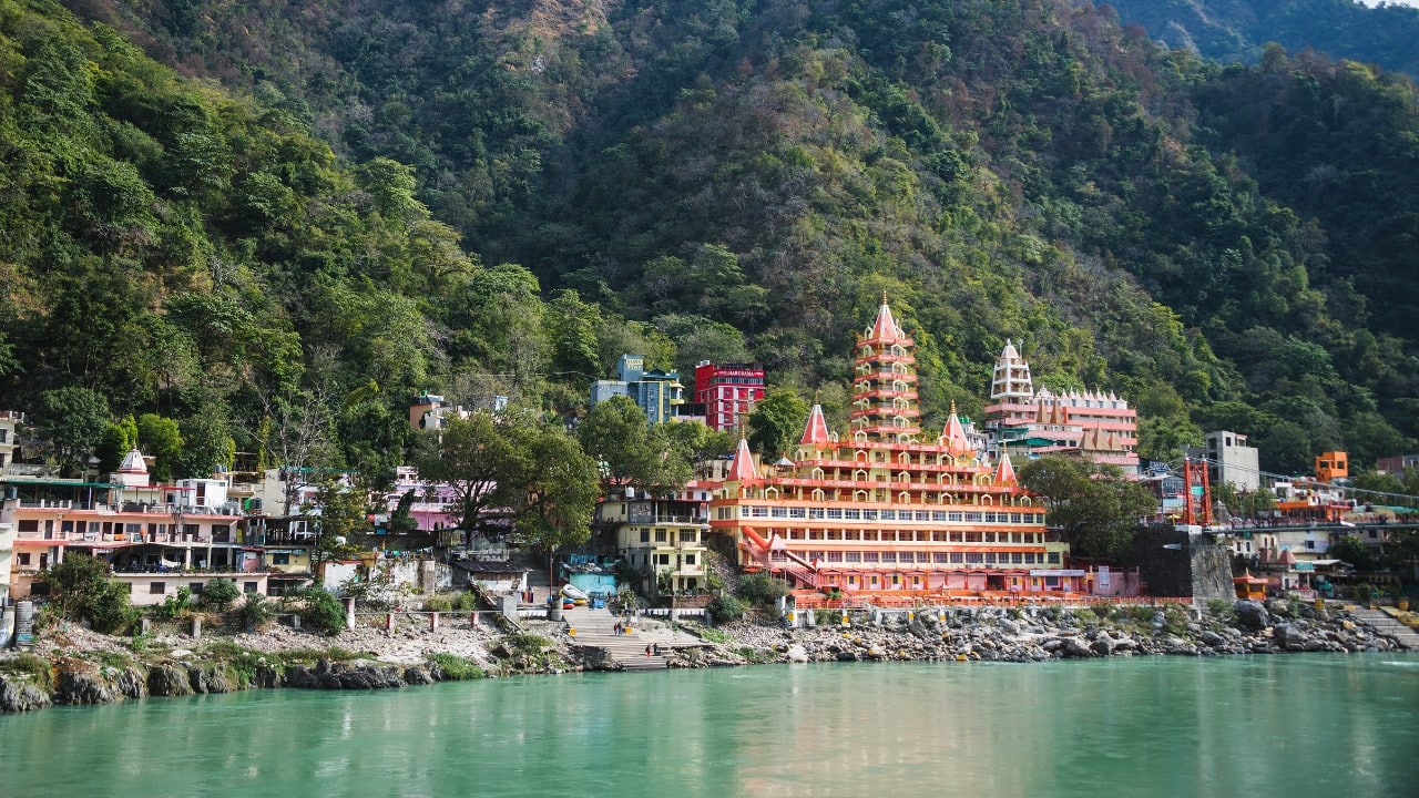 Experience yoga, rafting, and tranquility in Rishikesh with affordable stays and peaceful vibes. (Image: Canva)